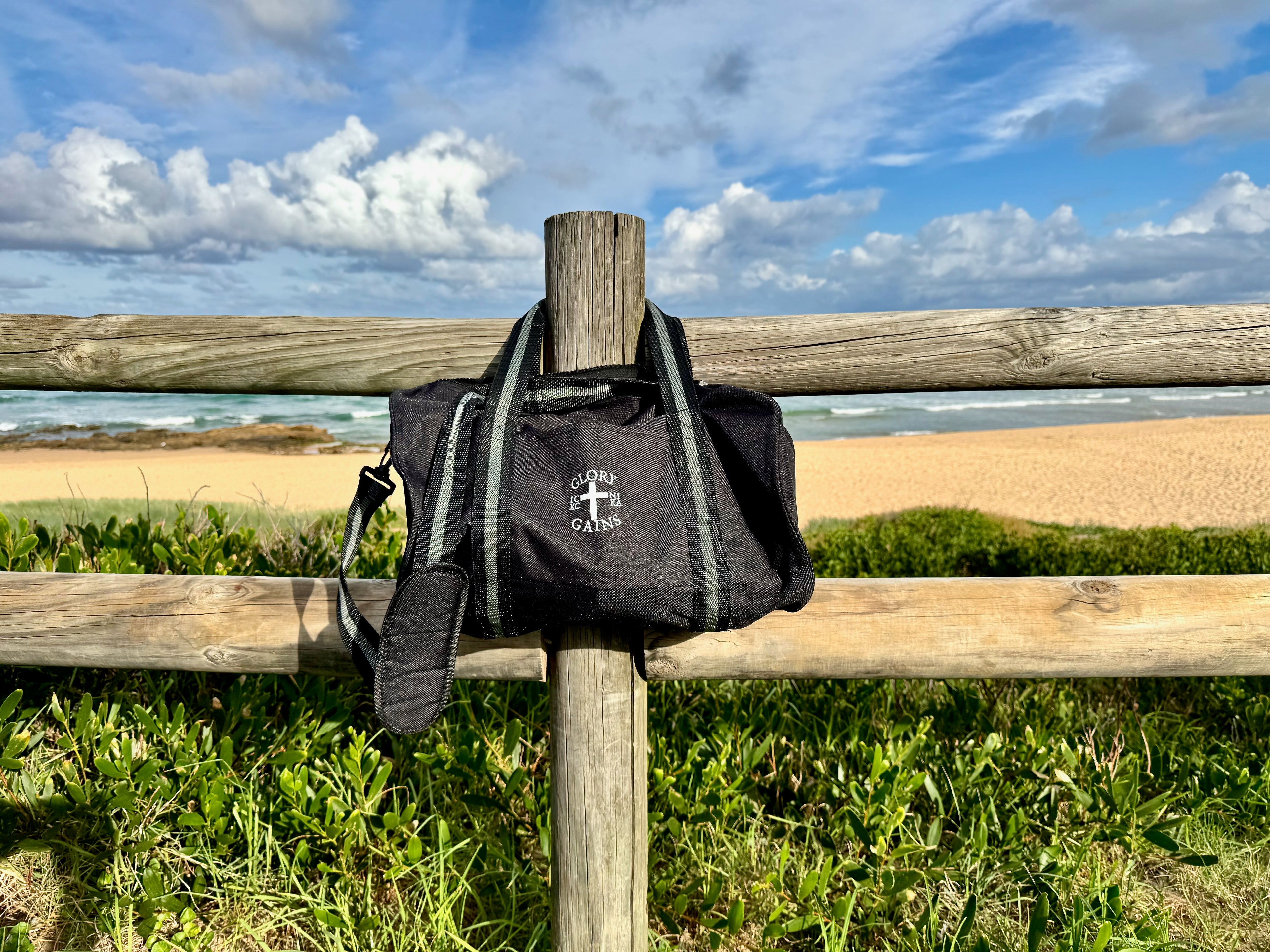 Glory and Gains bag hanging on post by beach